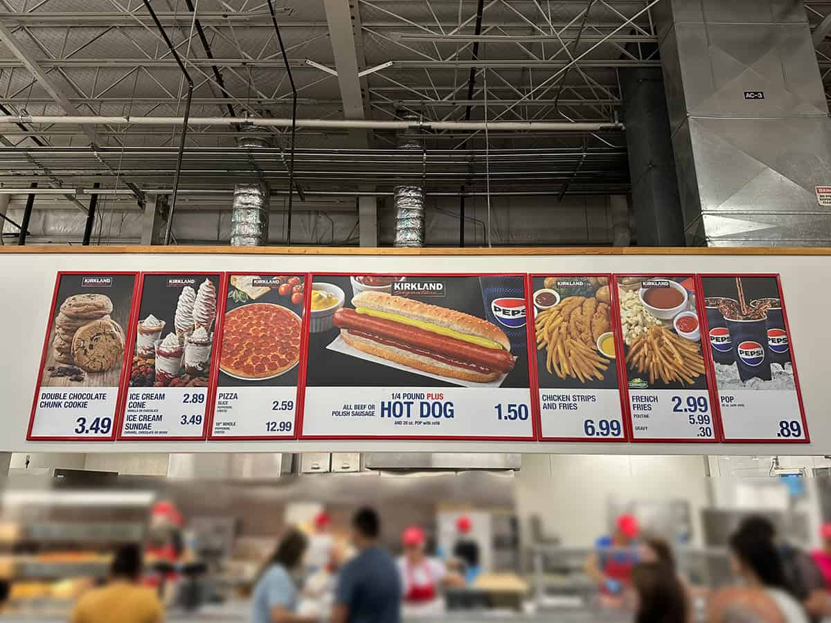 Image of the Canadian Costco food court menu signage with people waiting for their food. 