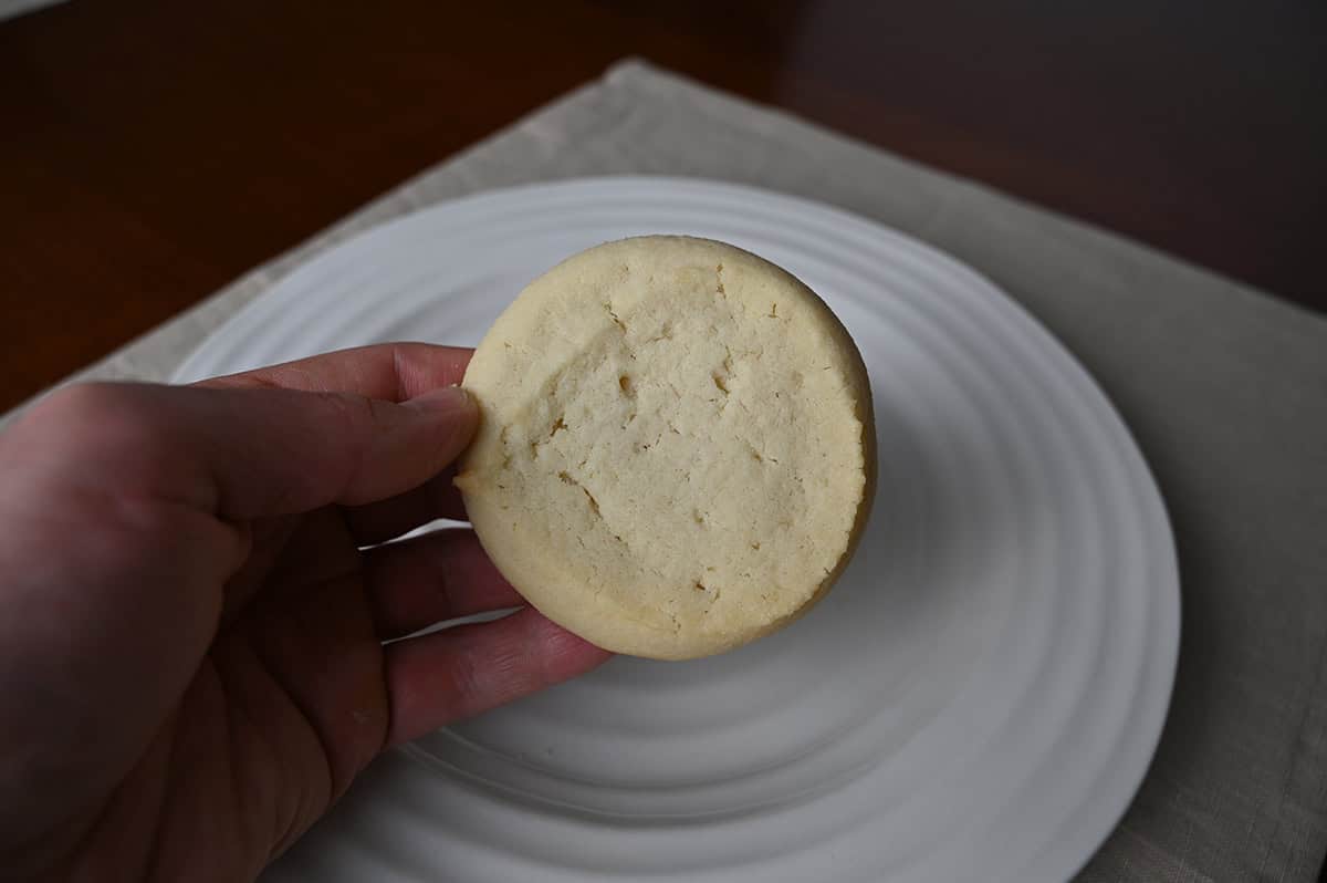 Image of a hand holding one Costco Kirkland Signature Butter Shortbread Cookie close to the camera.