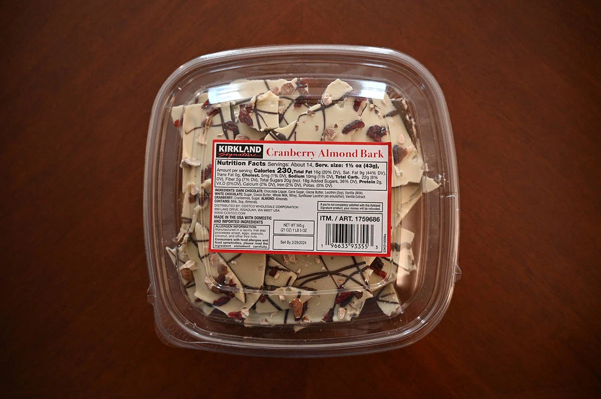 Image of the Costco Kirkland Signature Cranberry Almond Bark container sitting on a table unopened.