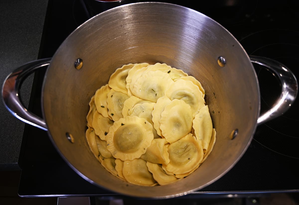 Top down image of a pot of ravioli after it's been boiled and drained. There is no sauce on it.