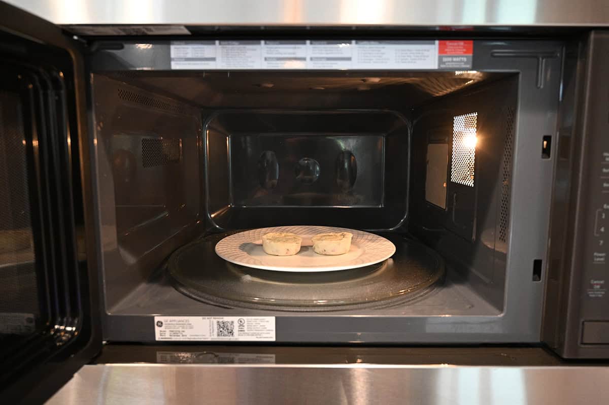 Image of two egg white bites served on a white plate in a microwave.