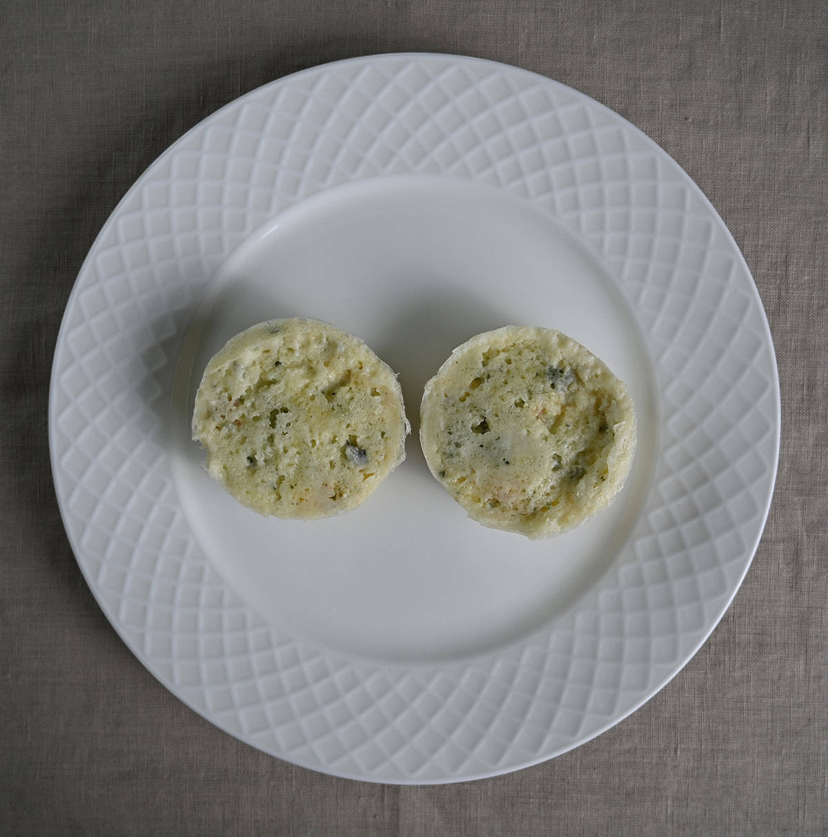 Top down image of two microwaved egg white bites sitting on a plate.