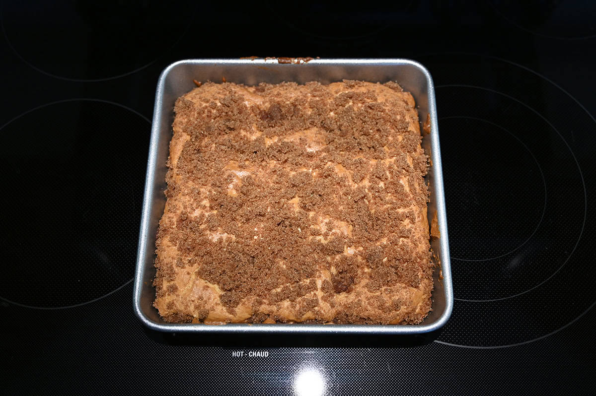 Top down image of a square baking pan with a baked cinnamon swirl cake in it.
