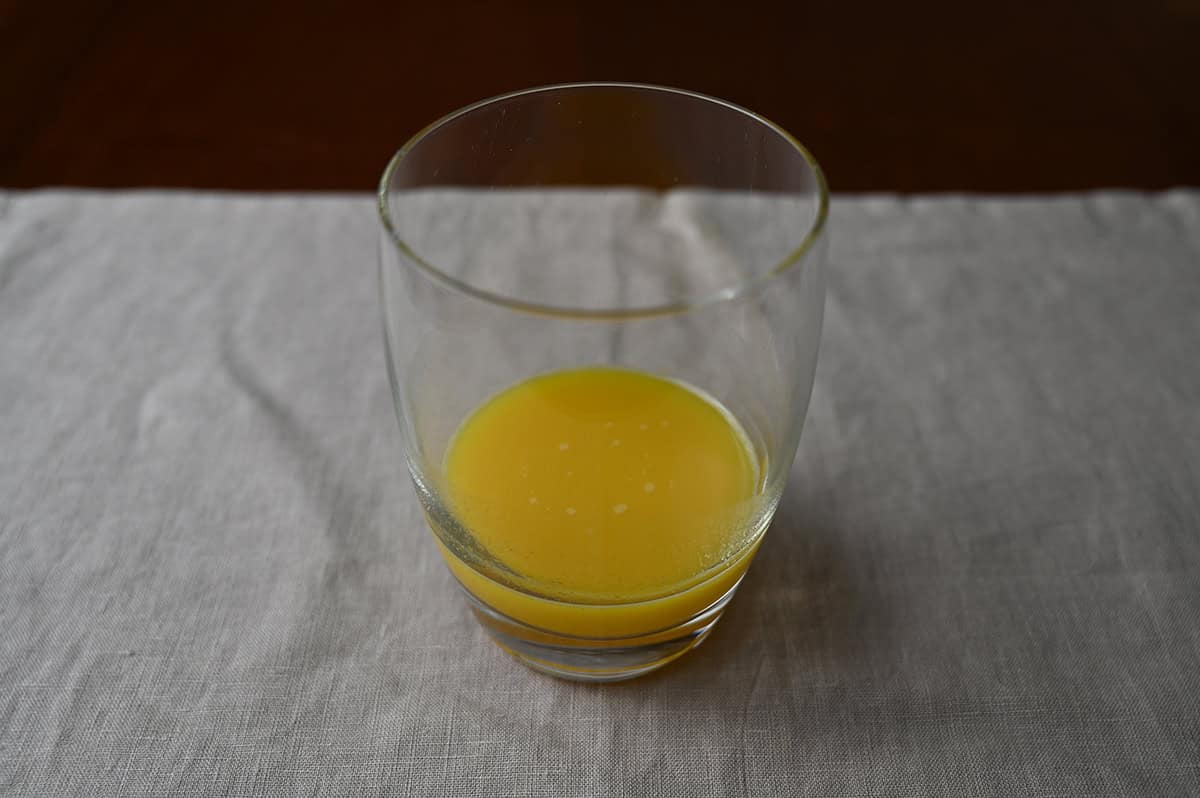 Image of a clear glass with ginger defence poured into the glass, there is not much in the glass, just a bit in the bottom.