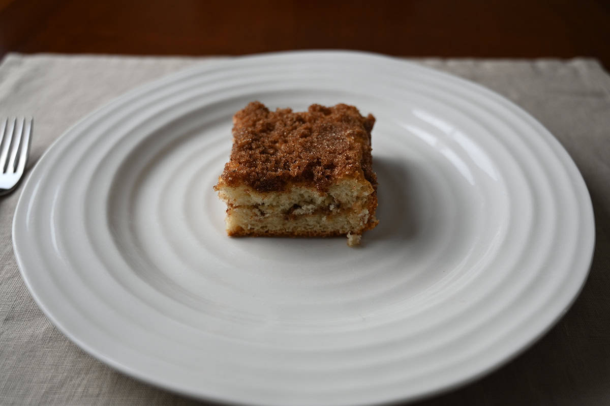 Top down sideview image of one piece of cinnamon swirl cake served on a white plate.