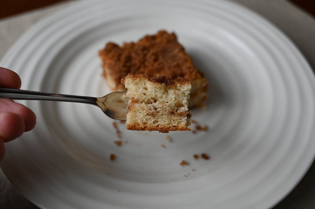 Closeup image of a fork with a bite of cinnamon swirl cake on it.