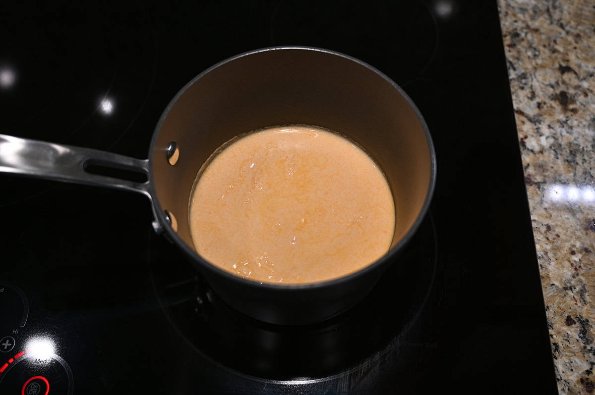 Top down image of a pot of lobster bisque being heated on the stove.