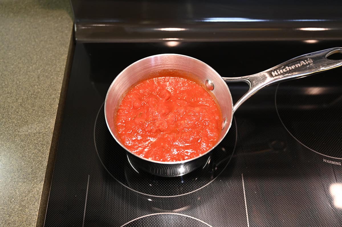 Top down image of the marinara sauce being heated in a pot on the stove.