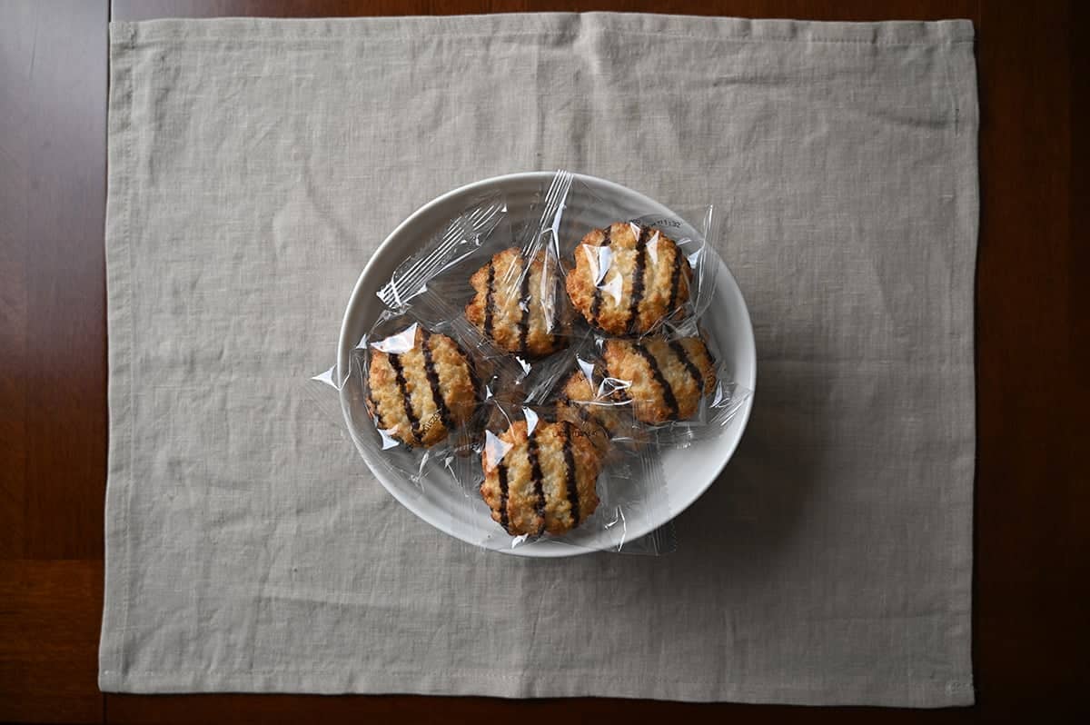 Top down image of a bowl of individually wrapped coconut cookies.
