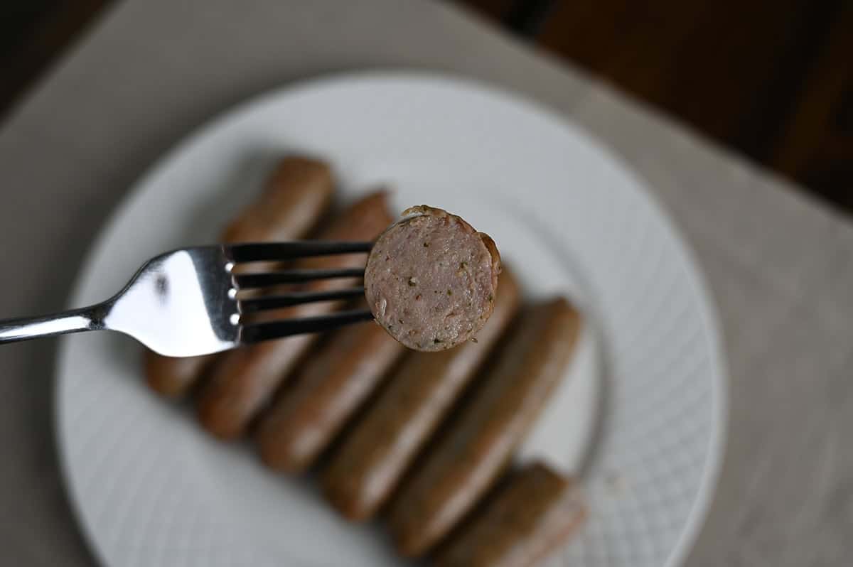 Closeup image of a fork with a slice of sausage on the fork so you can see the middle of the sausage.