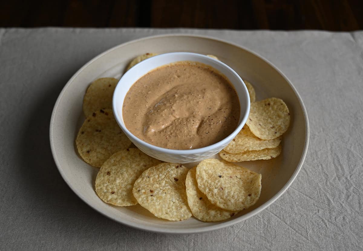 Sideview image of a plate of tortilla chips with a bowl of bitchin' sauce in the center of the plate.