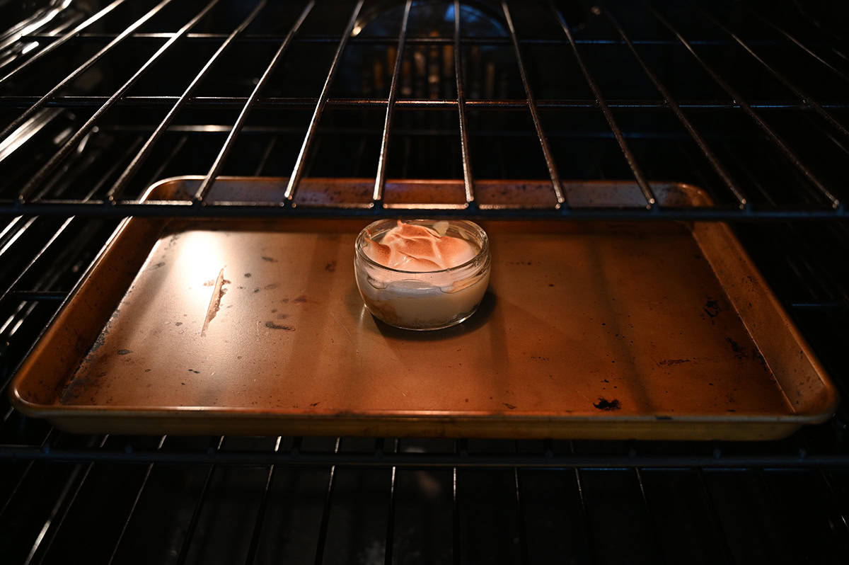 Image of one pie on a baking sheet heating in the oven.