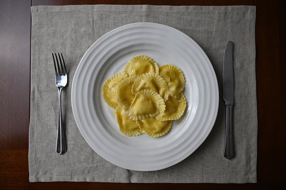 Top down image of a white plate with ravioli served on top of it.