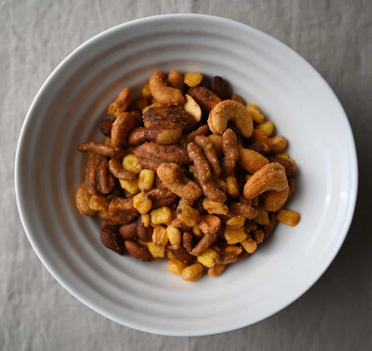 Top down image of a white bowl full of the snack mix. 