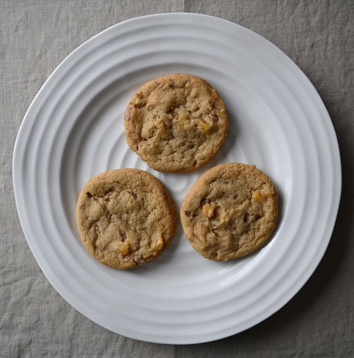 Top down image of three cookies served on a white plate.