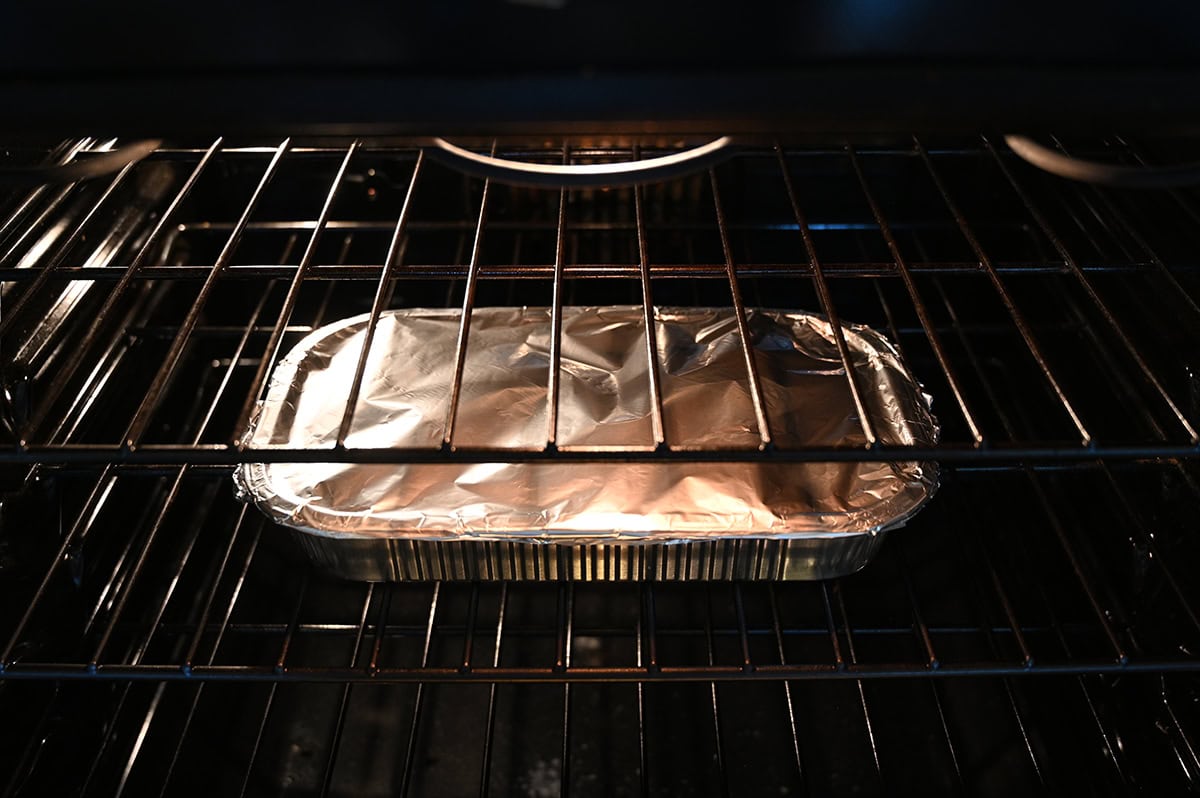 Image of a tray covered in aluminum foil in an oven being baked.