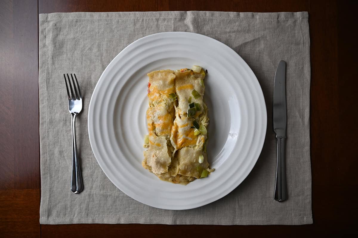 Top down image of a plate with two enchiladas served on it.