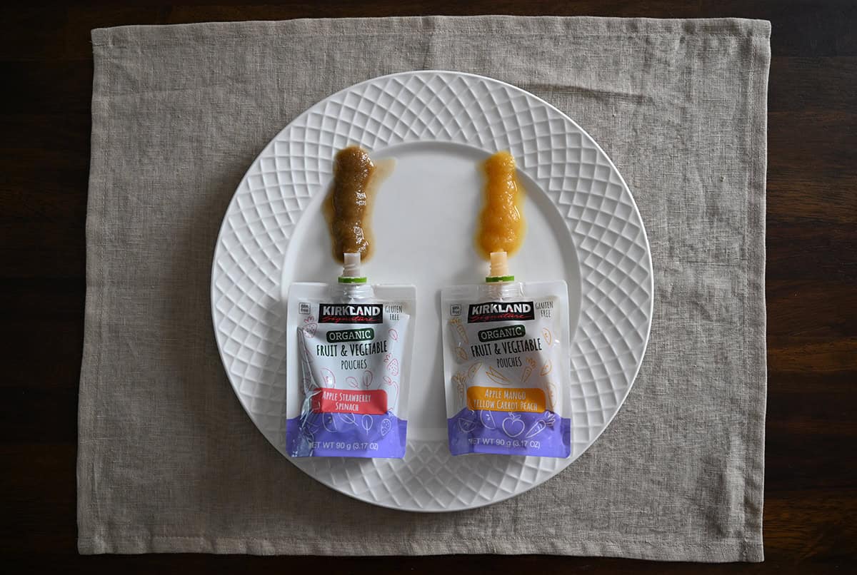 Top down image of both flavors of pouches laying on a white plate, the pouches have been squeezed out onto the plate so you can see what the puree looks like.