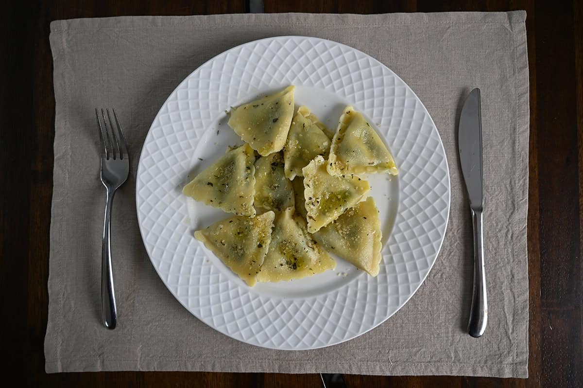 Top down image of a white plate with ravioli served on top.