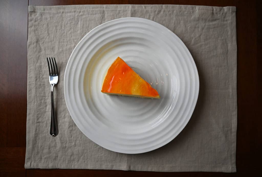 Top down image of one perfectly sliced mango passionfruit cake served on a white plate.