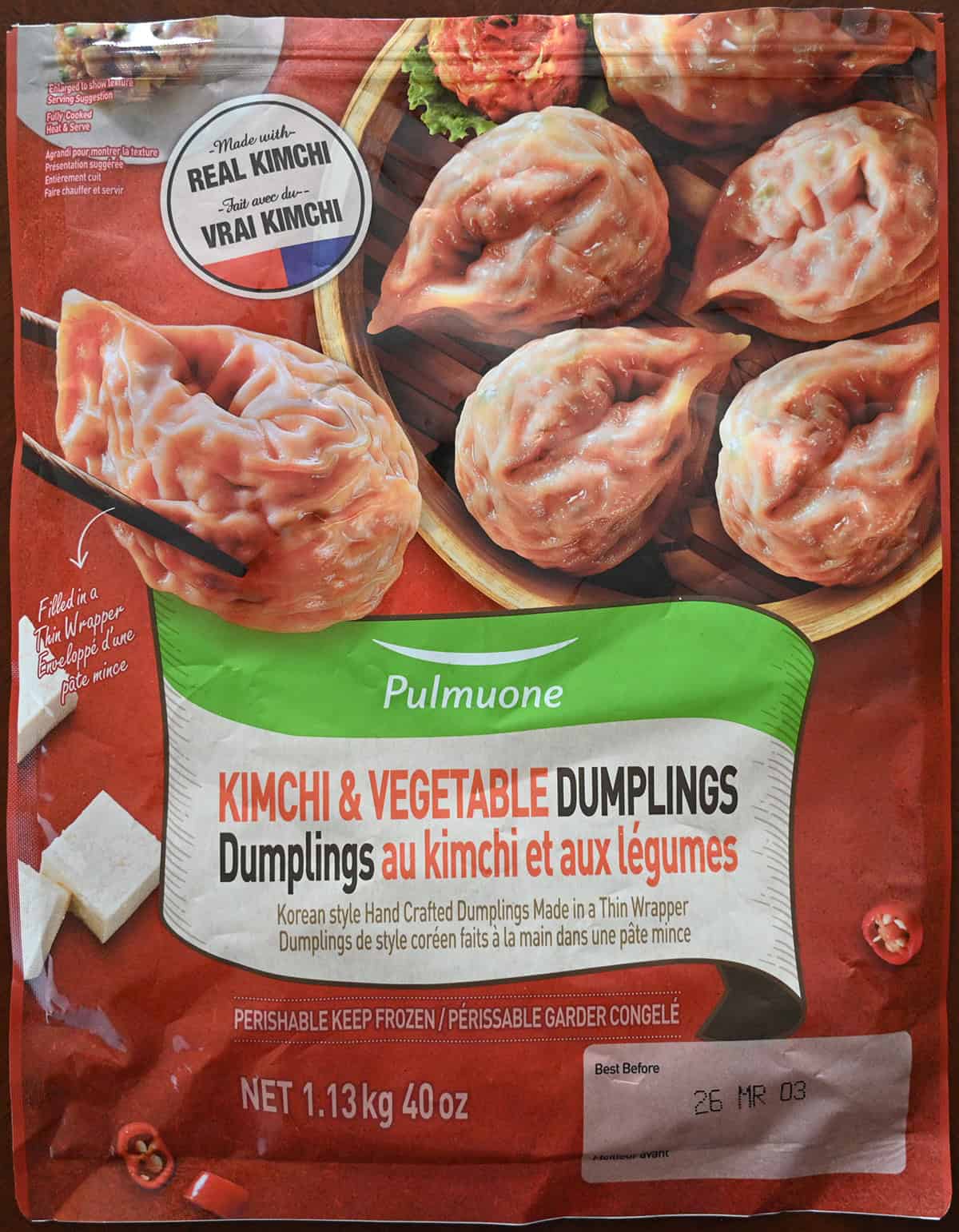 Closeup image of the front of the bag of the Pulmuone bag showing they're made with real kimchi and the best before date.