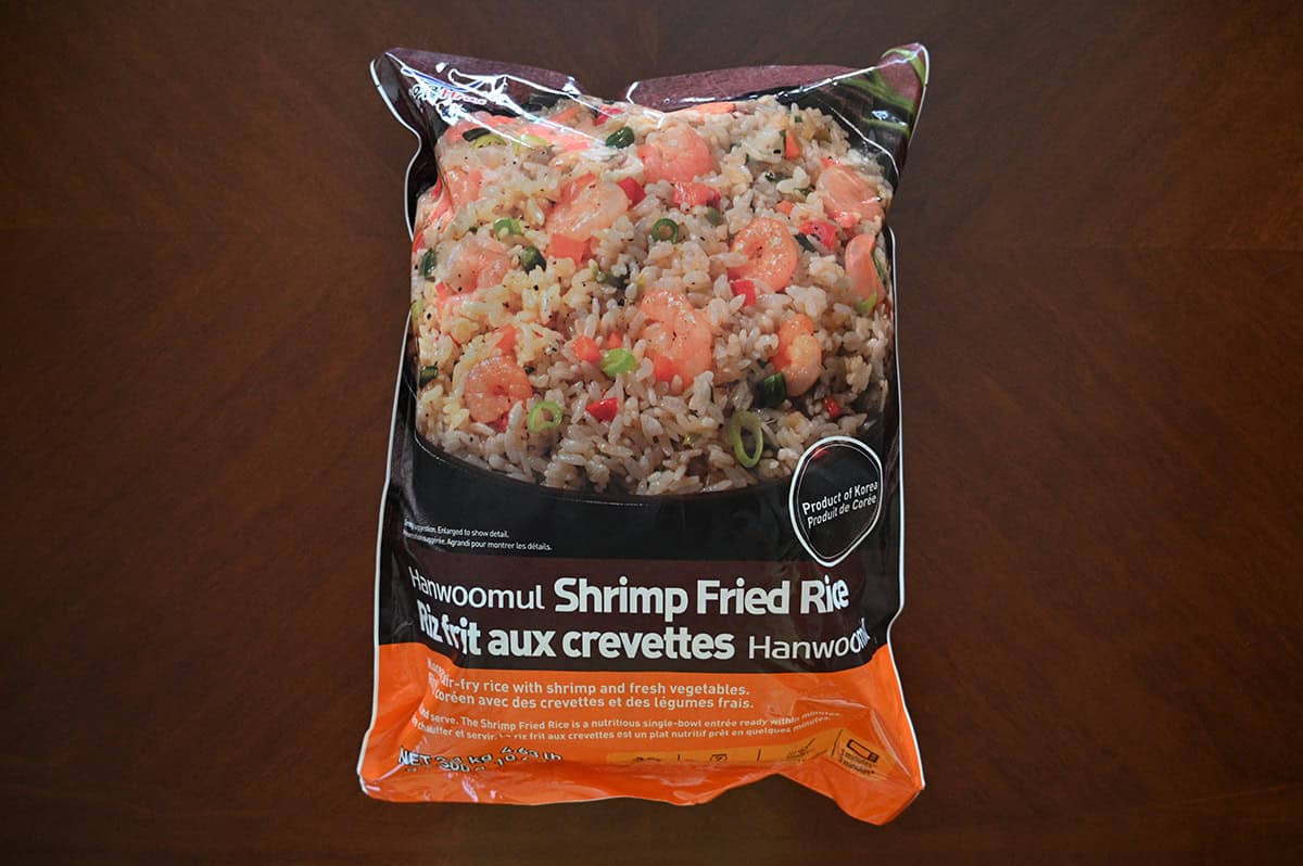 Image of the Costco Hanwoomul Shrimp Fried Rice bag sitting on a table unopened. 