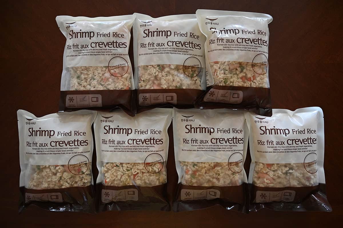 Top down image of seven individual sized bags of shrimp fried rice sealed and sitting on a table.