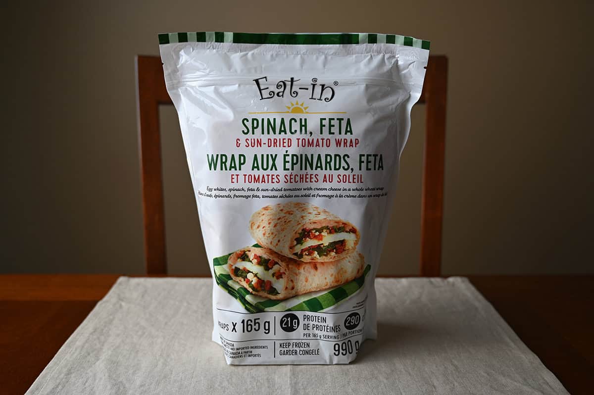 Image of the Costco Eat-In Spinach, Feta & Sun-Dried Tomato Wrap bag sitting on a table unopened.