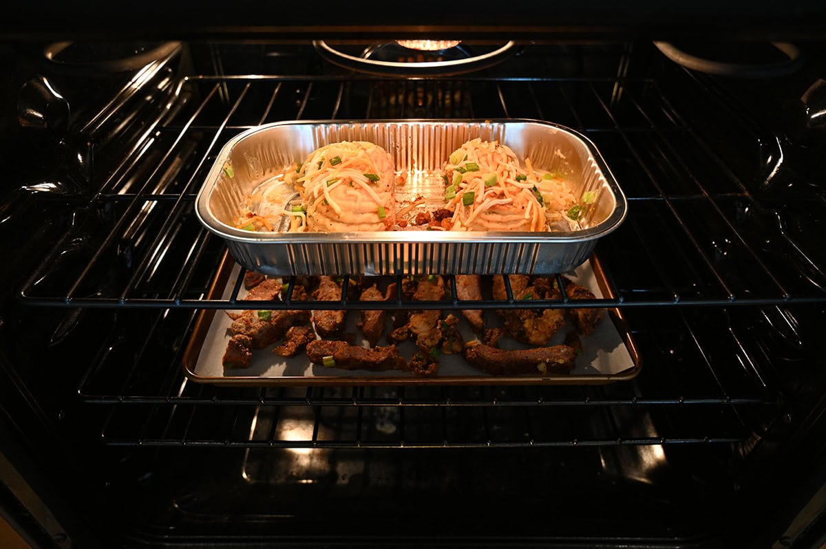 Image of two baked potatoes cooking in the oven as well as the rib ends cooking in the oven.