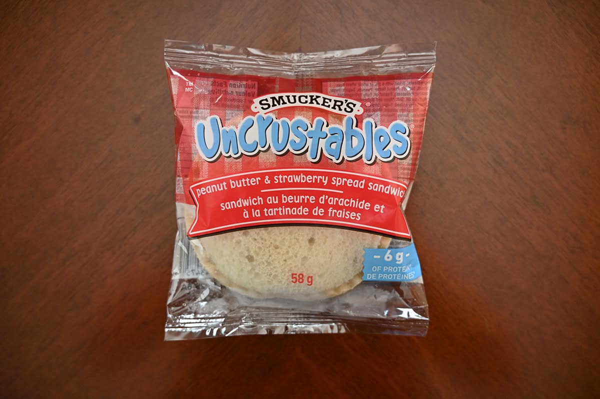 Top down image of one unopened packaged Uncrustable sitting on a table.