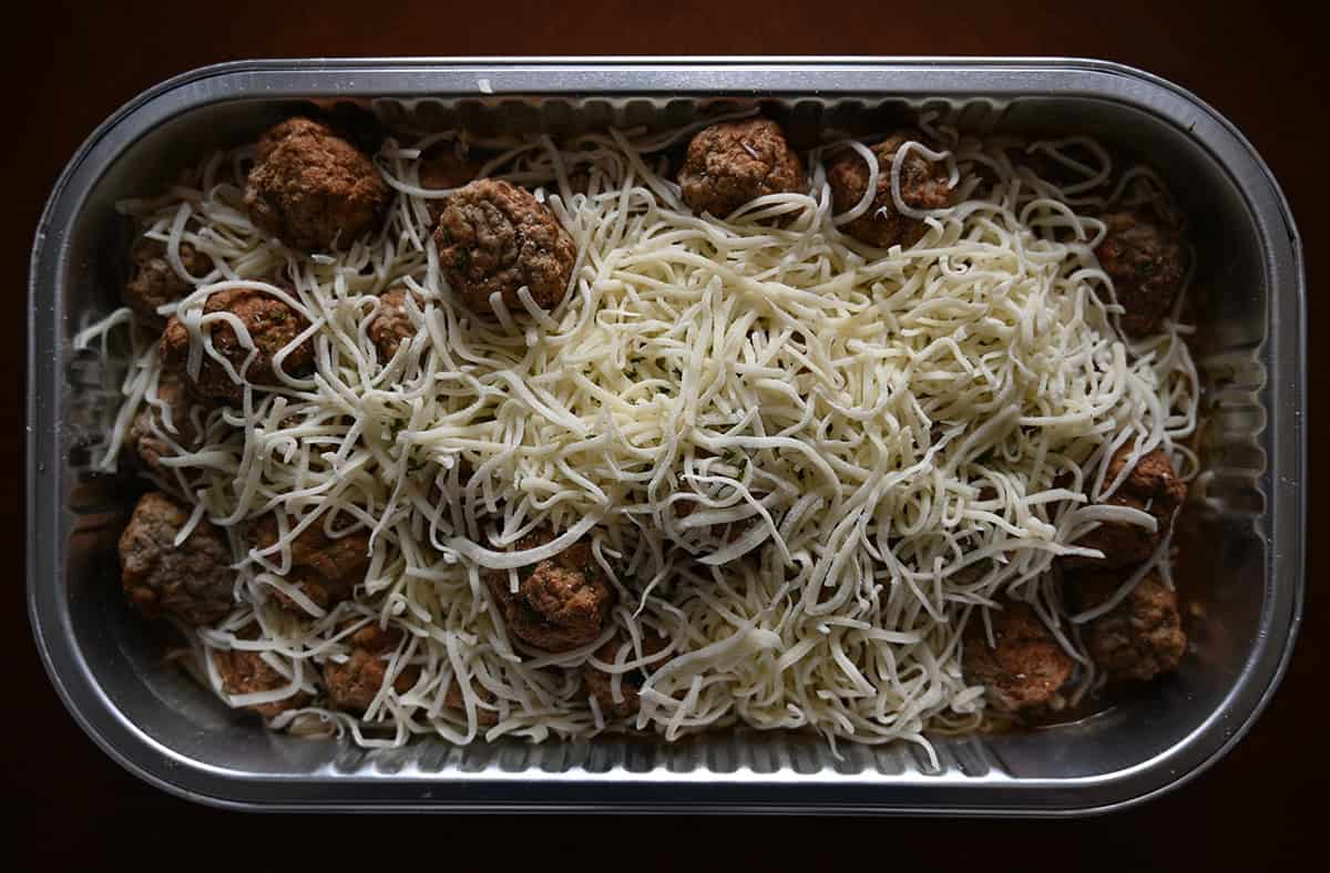 Top down image of the Costco Kirkland Signature French Onion Meatball Bake sitting on a table with the lid off. uncooked/