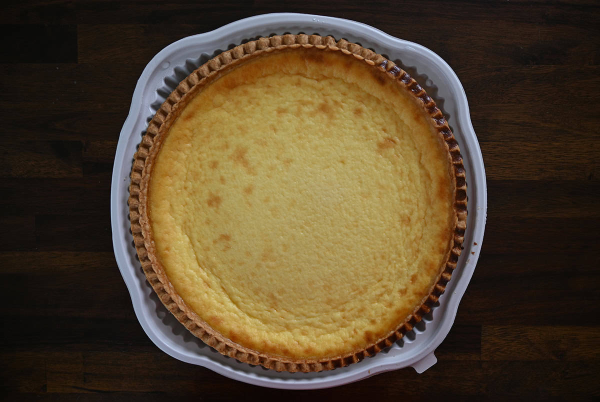 Top down image of a Costco Kirkland Signature Custard Pie sitting on a table before slicing it.