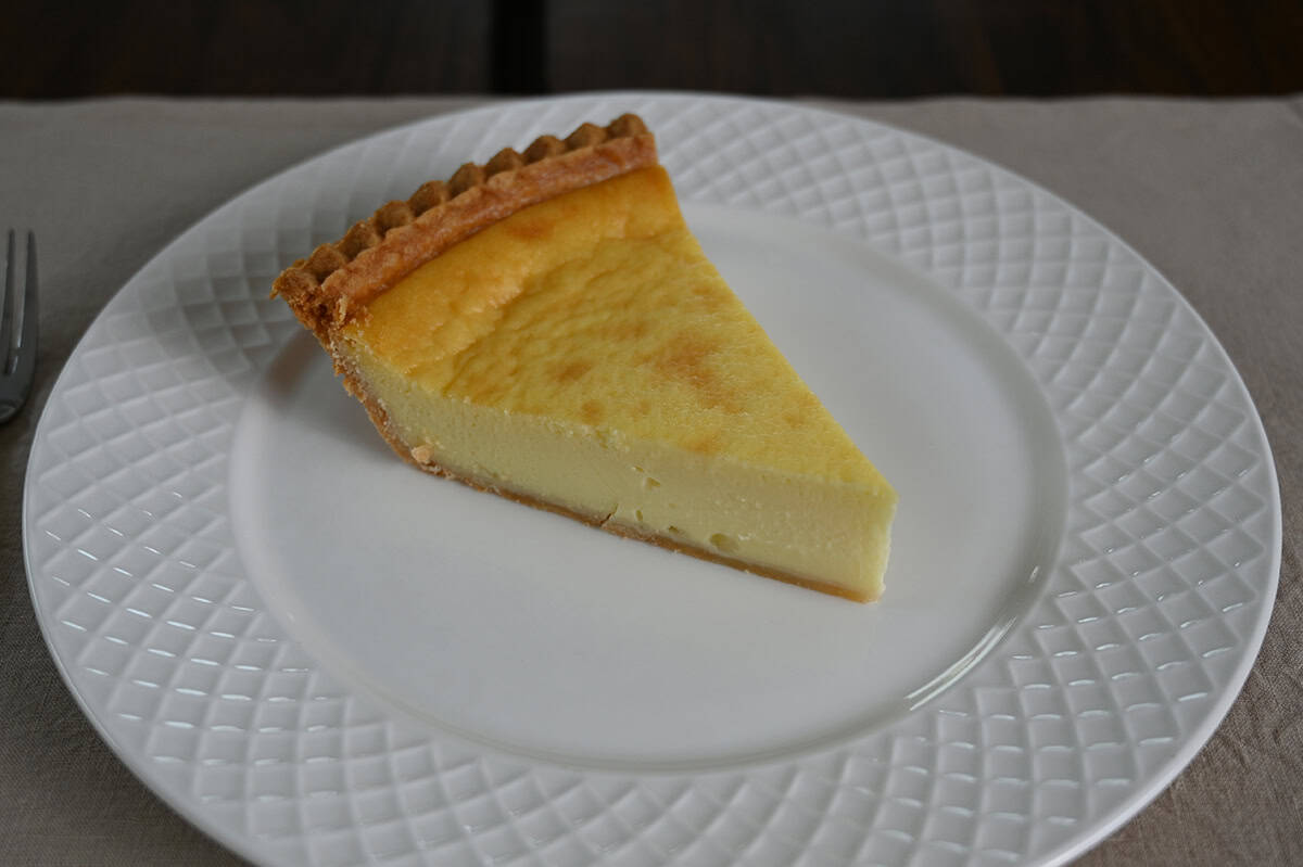 Closeup sideview image of a slice of custard pie served on a white plate.