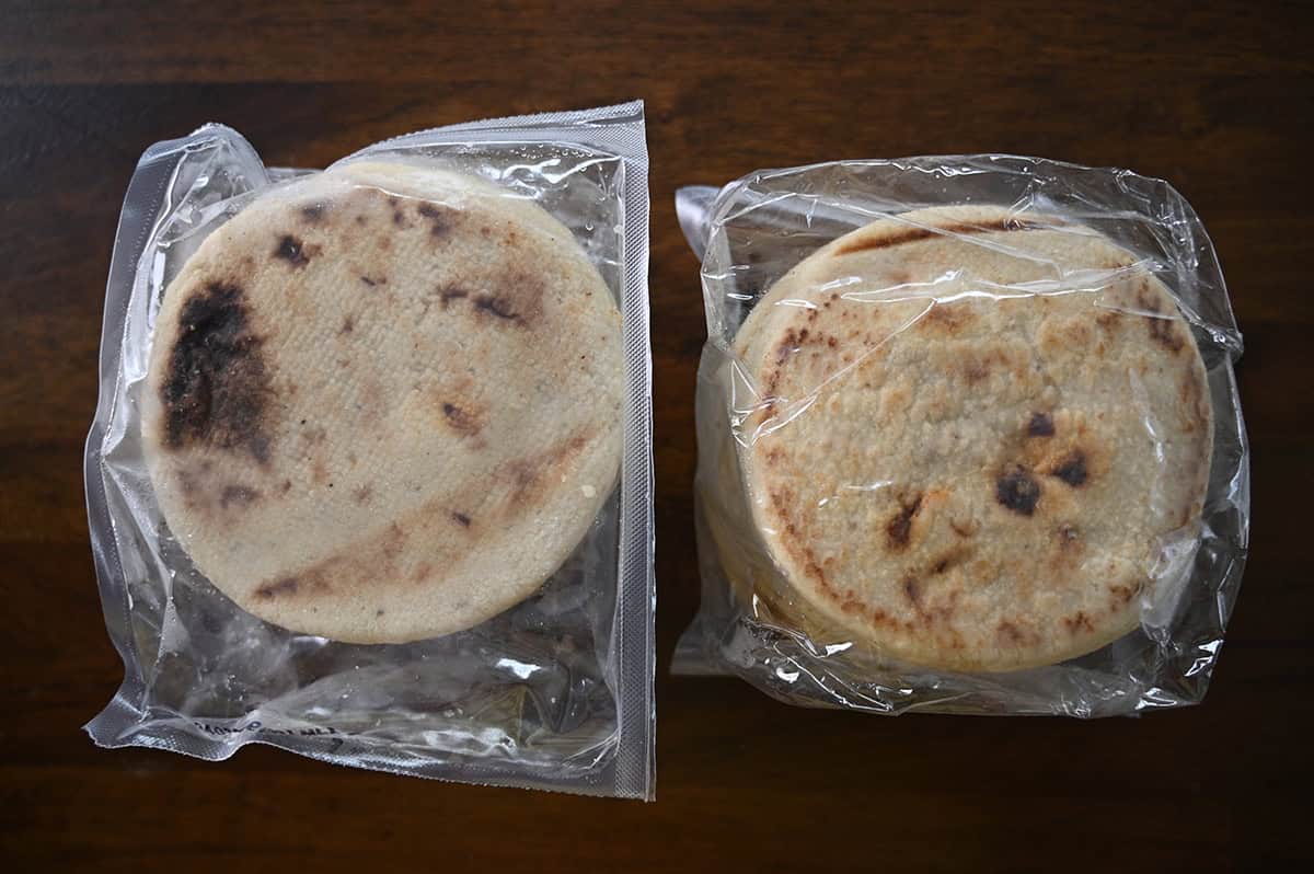 Image of two pupusas individually wrapped and sitting on a table.