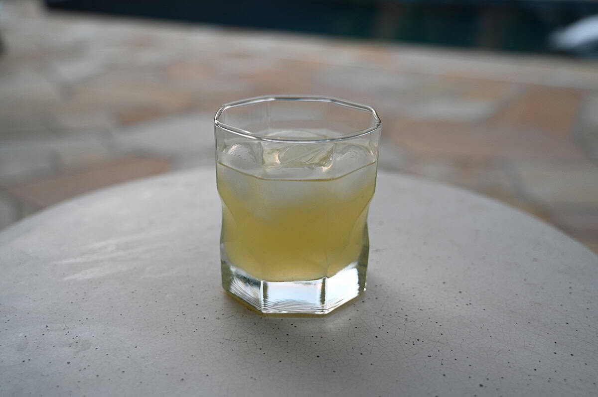 Image of a clear glass with a margarita in it sitting on a table. 