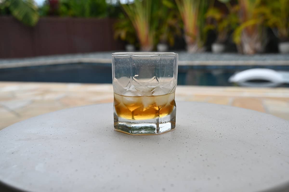 Image of the Kirkland Signature Orange Liqueur served in a glass over ice sitting by a pool. 