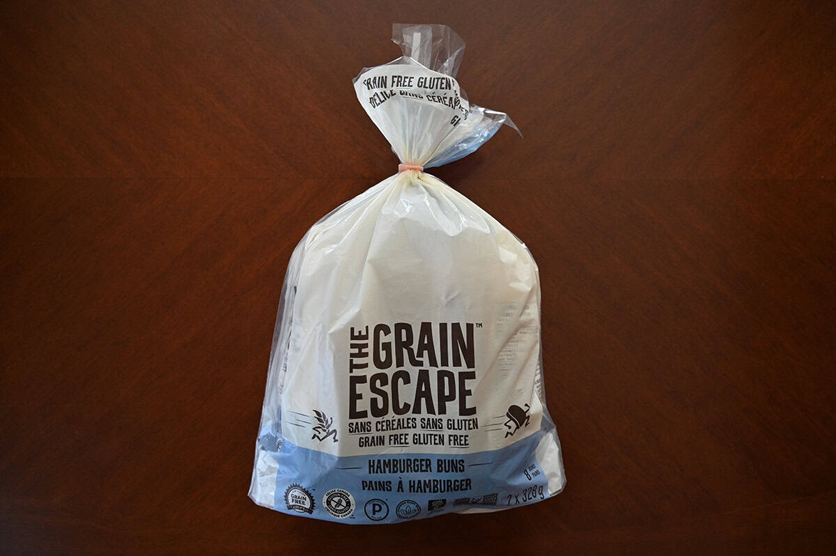 Image of The Grain Escape Hamburger Buns bag sitting on a table unopened.