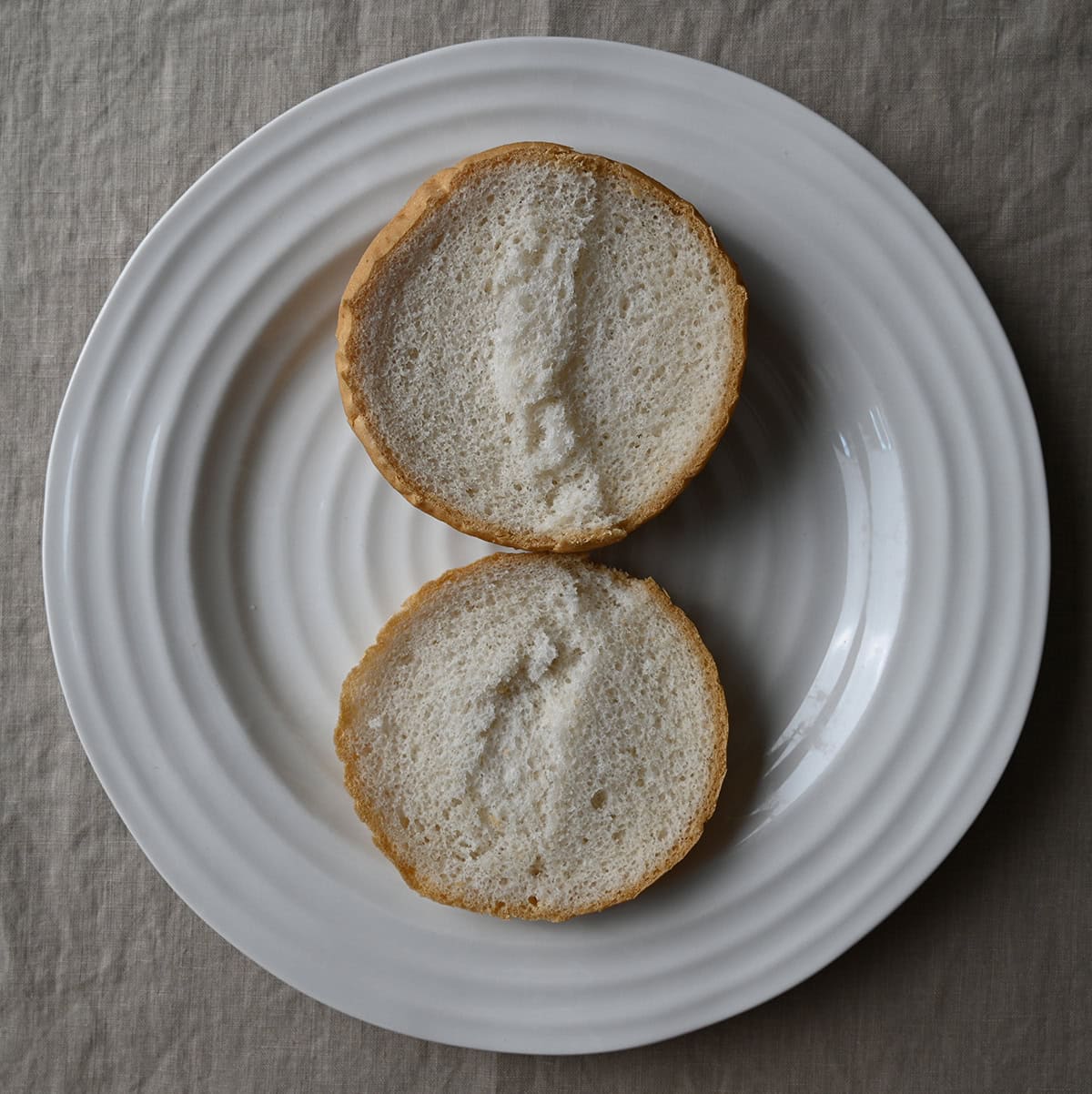 Image of an open bun on a plate showing what the inside of the bun looks like.