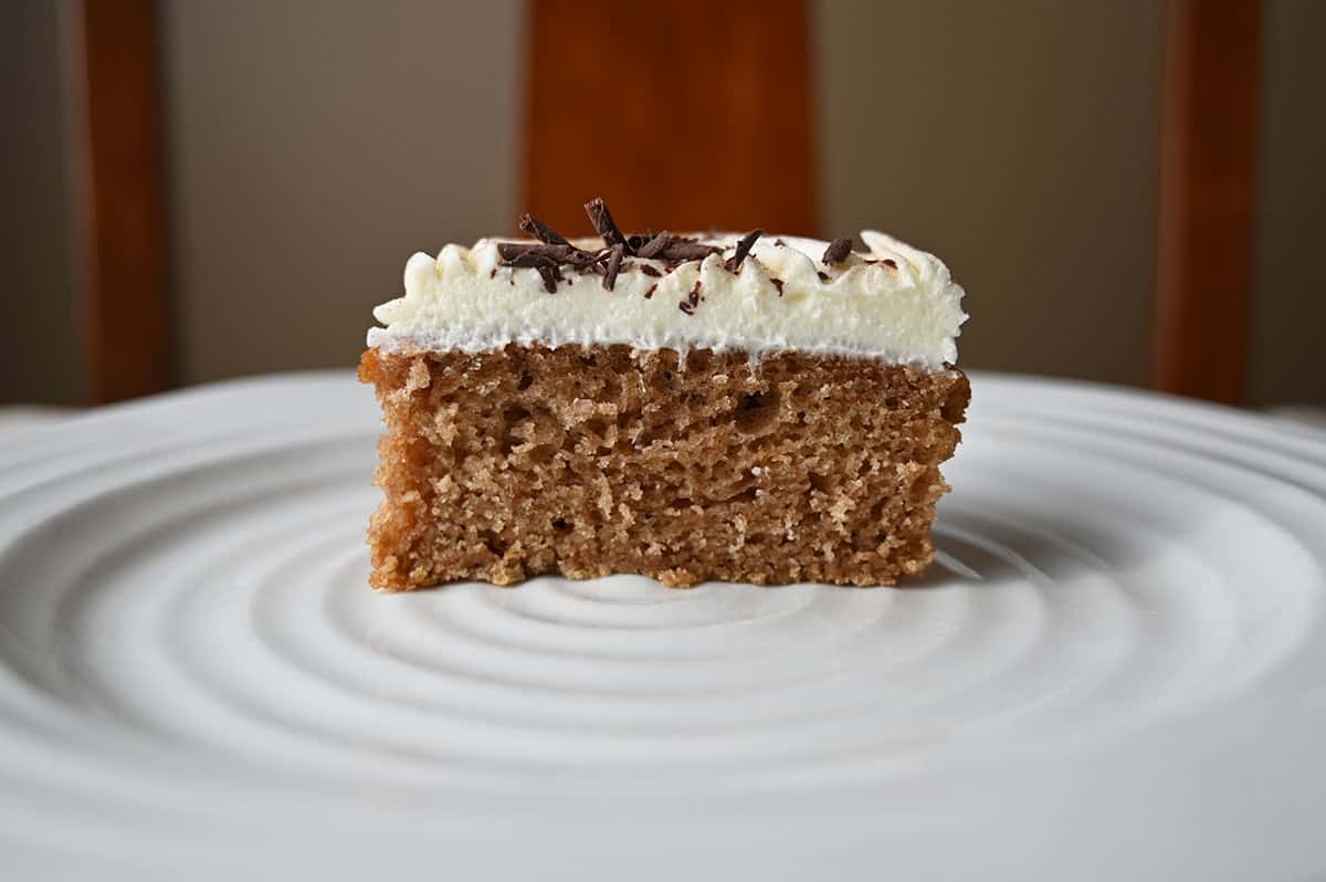 Image of one cinnamon roll mini cake cut in half served on a white plate so you can see the center.