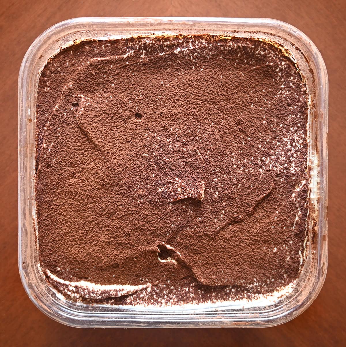 Image of the Costco Kirkland Signature Tiramisu Scoop Cake sitting on a table with the lid off.