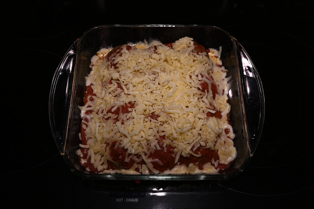 Image of the meatball bake with shredded mozzarella on it prior to it going in the oven.