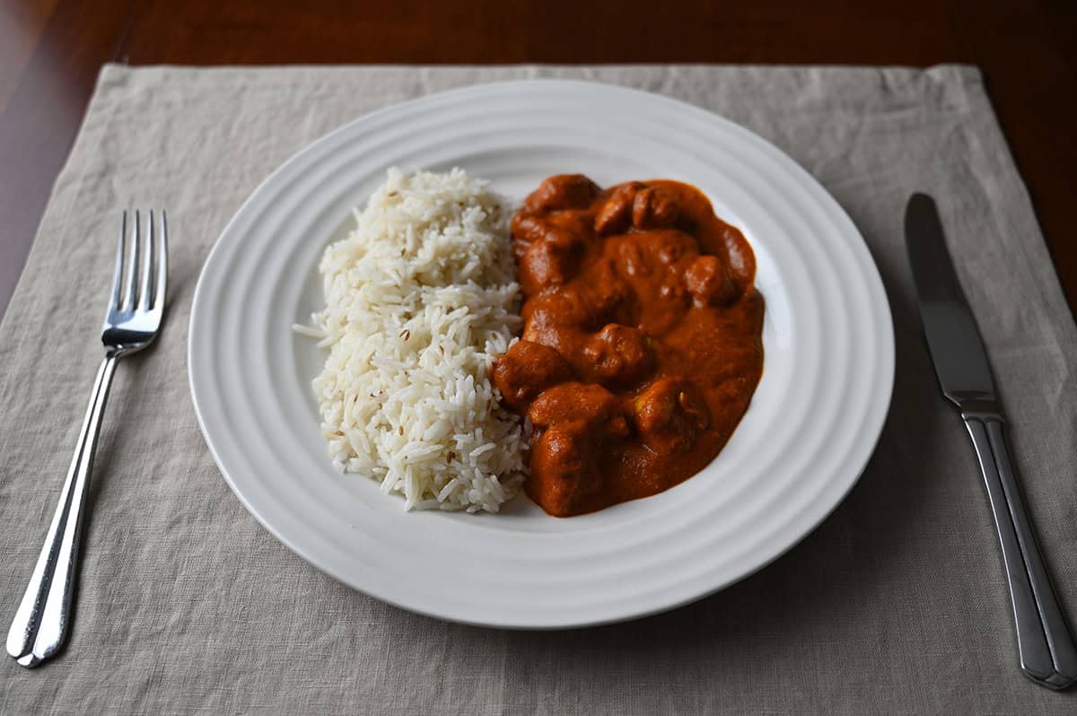 Image of a plate of curry with rice beside it.