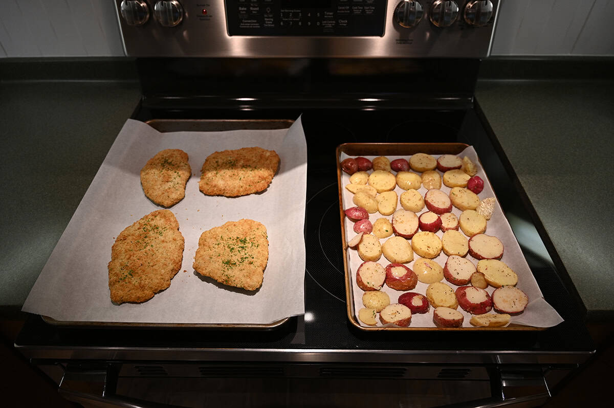 Image of a baking tray with pork cutlets on it beside a baking tray with potato slices on it ready to go into an oven.