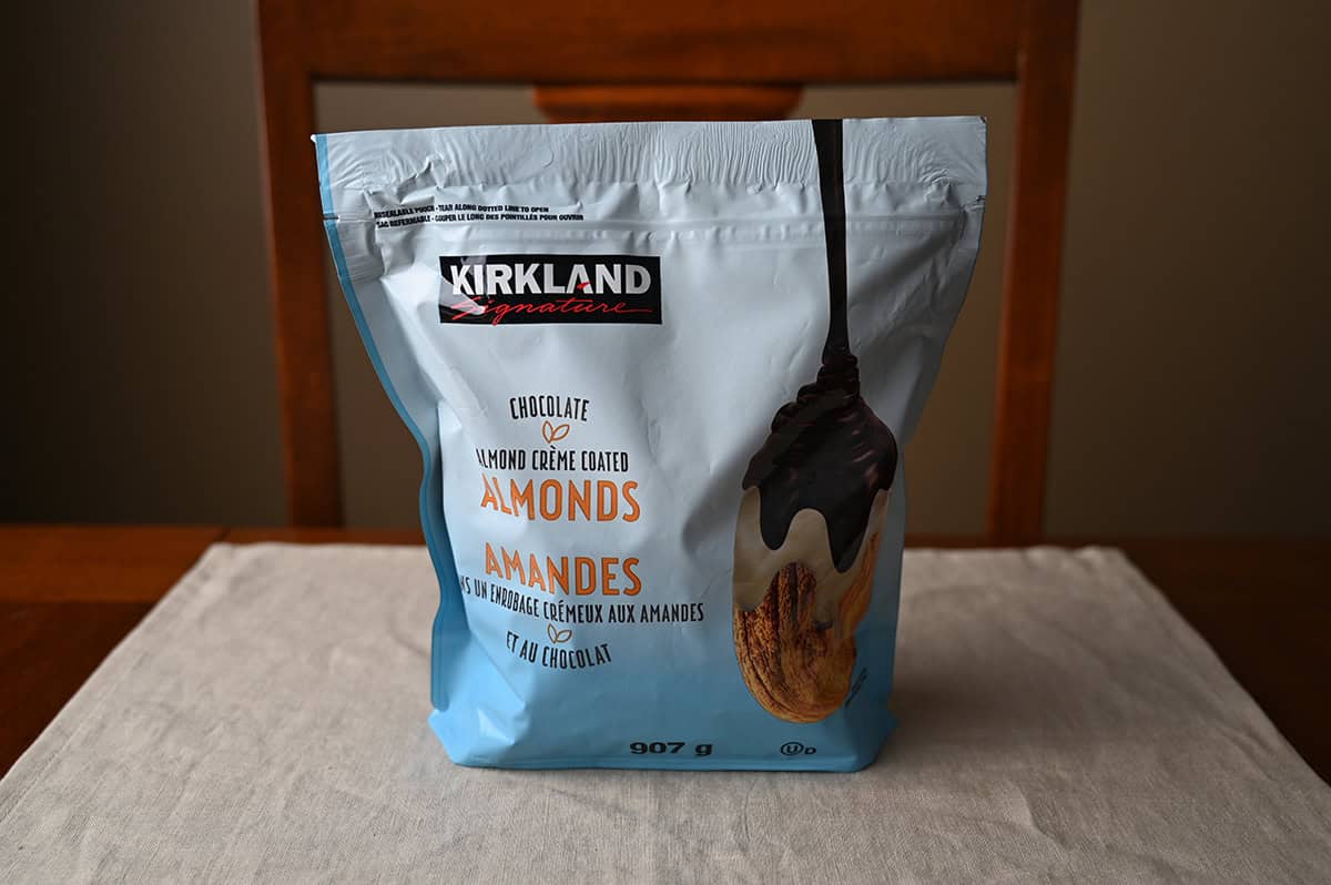 Image of the Costco Kirkland Signature Chocolate Almond Creme Coated Almonds bag sitting on a table unopened.