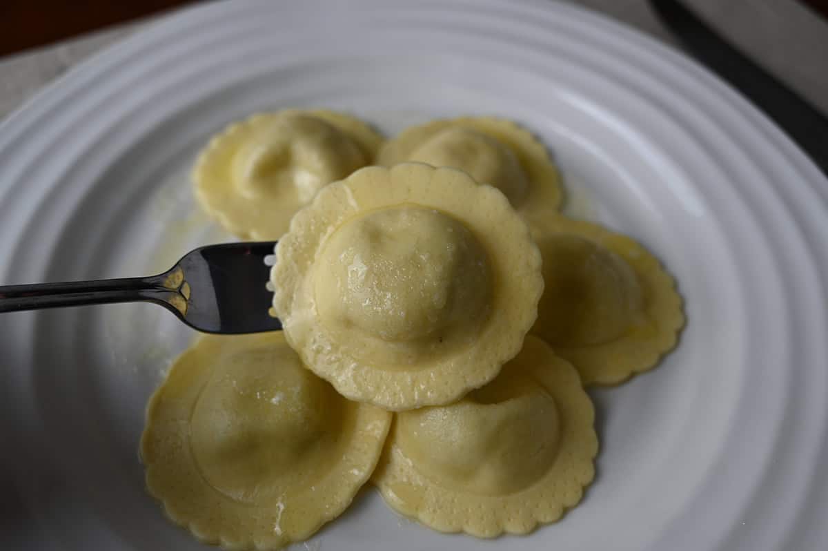 Closeup image of a fork with one piece of ravioli on it. 