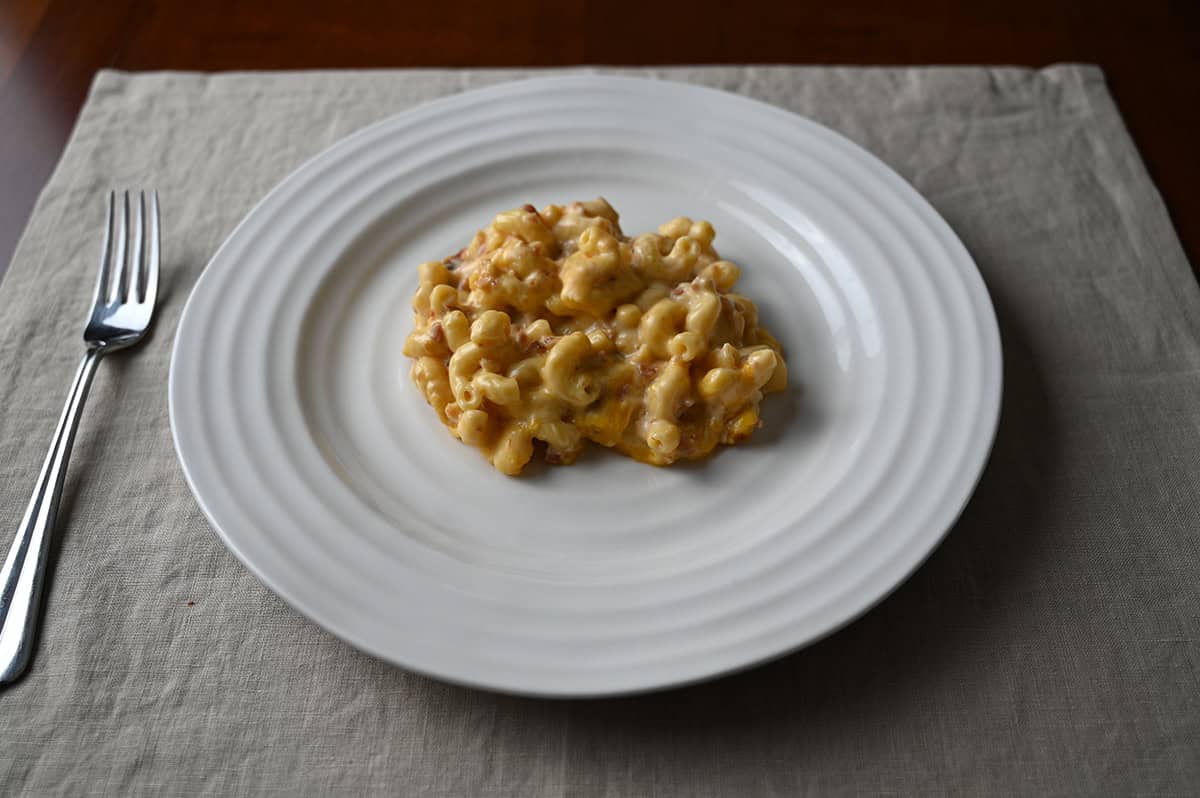 Image of a white plate with bacaon macaroni and cheese served on it.