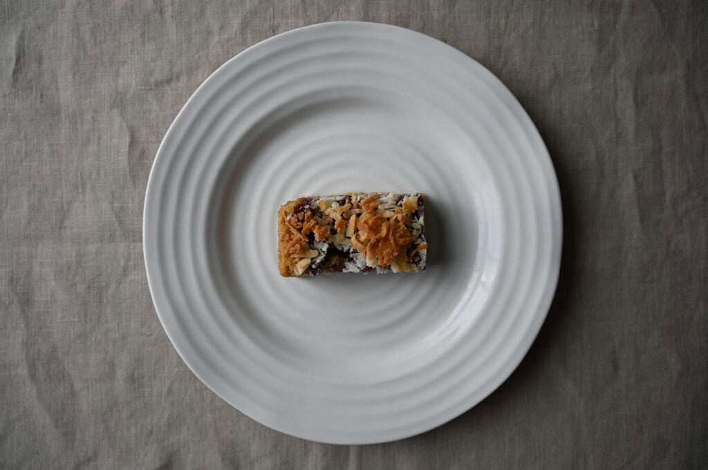 Image of a wildberry macaroon served on a white plate.