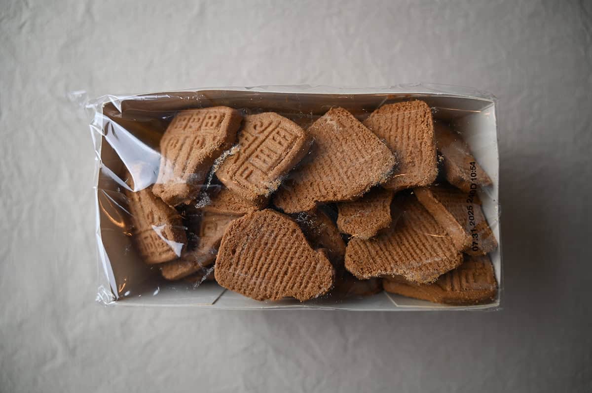 Image of a cardboard box filled with cookies and wrapped in plastic, unopened sitting on a table.