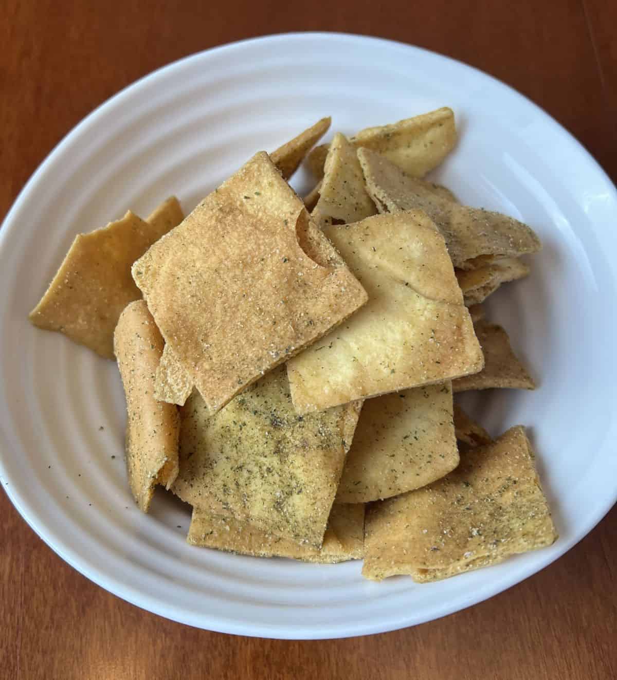 Top down image of a bowl of pita chips. 