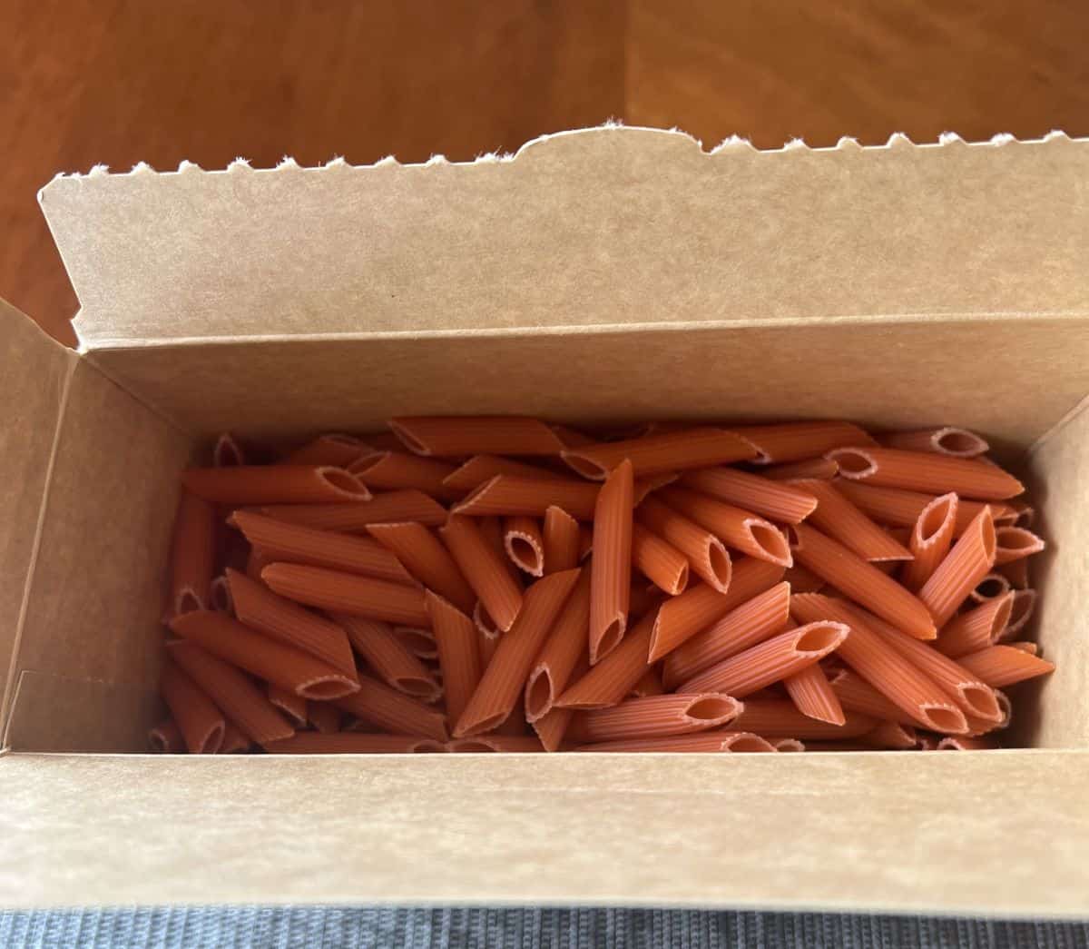 Top down image of the open box of penne showing the dry pasta in the box.